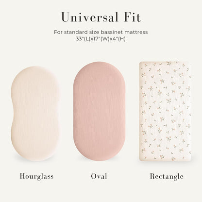 Three bassinet fitted sheets labeled Hourglass, Oval, and Rectangle on a light background. Text reads 'Universal Fit for standard size bassinet mattress 33x17x4 inches.' Sheets shown in cream, dusty pink, and a white floral print.