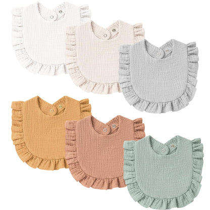 Six ruffled baby bibs in a 2-row arrangement, each with a textured muslin fabric and snap closure. Colors include white, cream, light gray, mustard yellow, dusty rose, and sage green.