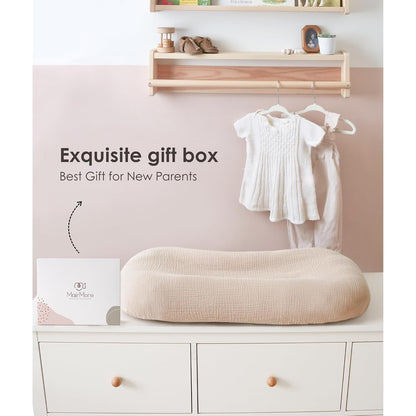 A beige textured muslin baby lounger cover draped over a lounger pad, displayed on a white dresser beside a white gift box labeled MairMore. Text reads 'Exquisite gift box, Best Gift for New Parents.'