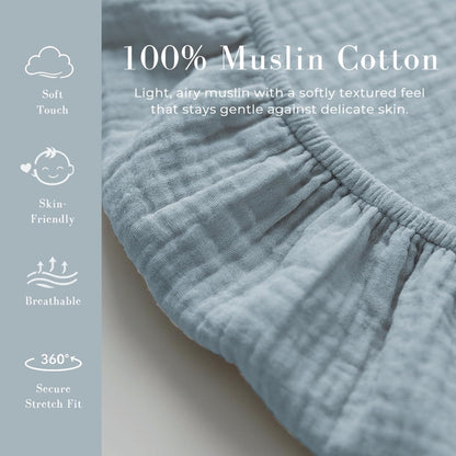 Close-up of light blue muslin cotton fabric with visible woven texture and an elastic gathered edge. Promotional text reads '100% Muslin Cotton' with icons for Soft Touch, Skin-Friendly, Breathable, and 360 Degree Secure Stretch Fit.