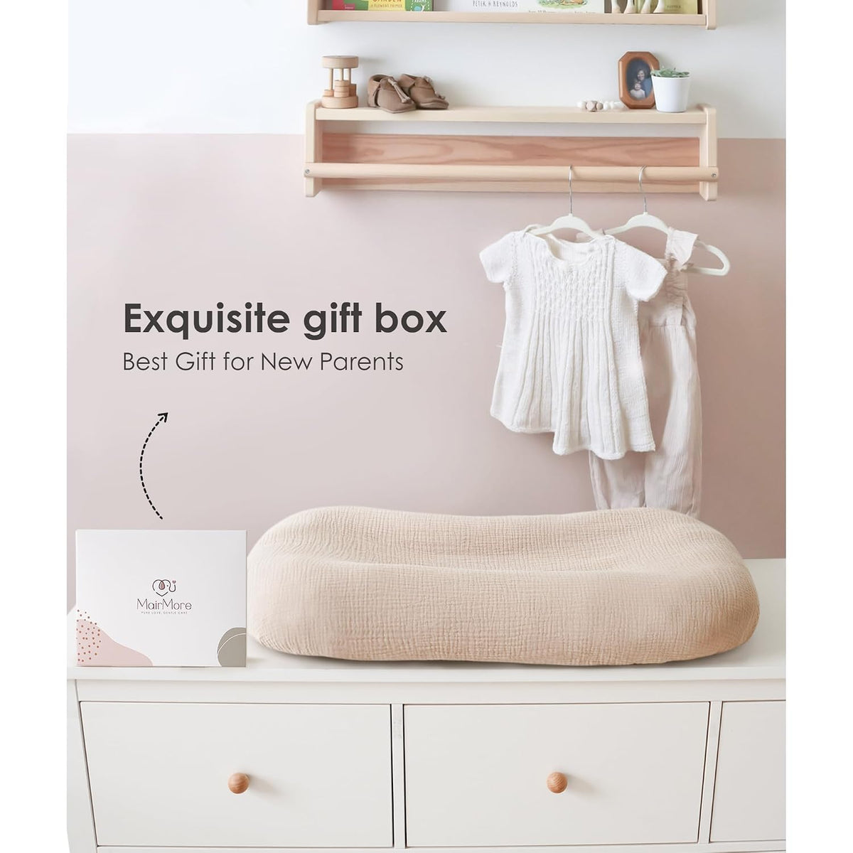 A beige textured muslin baby lounger cover displayed on a white dresser beside a MairMore gift box, set in a nursery with baby clothes hanging and a wooden shelf above. Text reads 'Exquisite gift box, Best Gift for New Parents.'