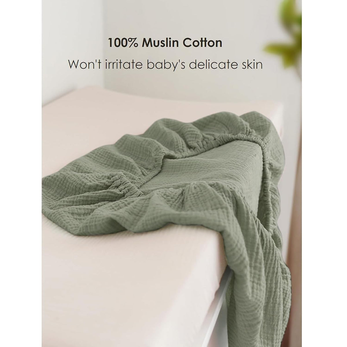 Sage green muslin cotton changing pad cover shown fitted on a white changing pad. Textured crinkled fabric with elasticized edges. Text reads '100% Muslin Cotton - Won't irritate baby's delicate skin.'