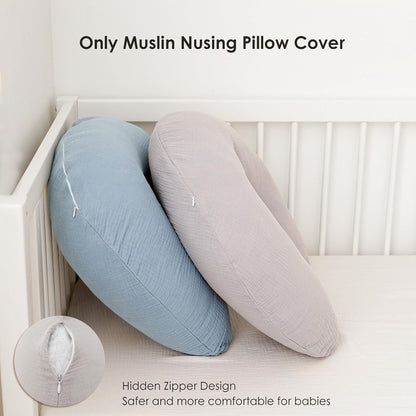 Two crescent-shaped nursing pillow covers leaning against a white crib rail -- one in dusty blue, one in light gray -- both with visible muslin texture. A circular inset shows a close-up of the hidden zipper closure.