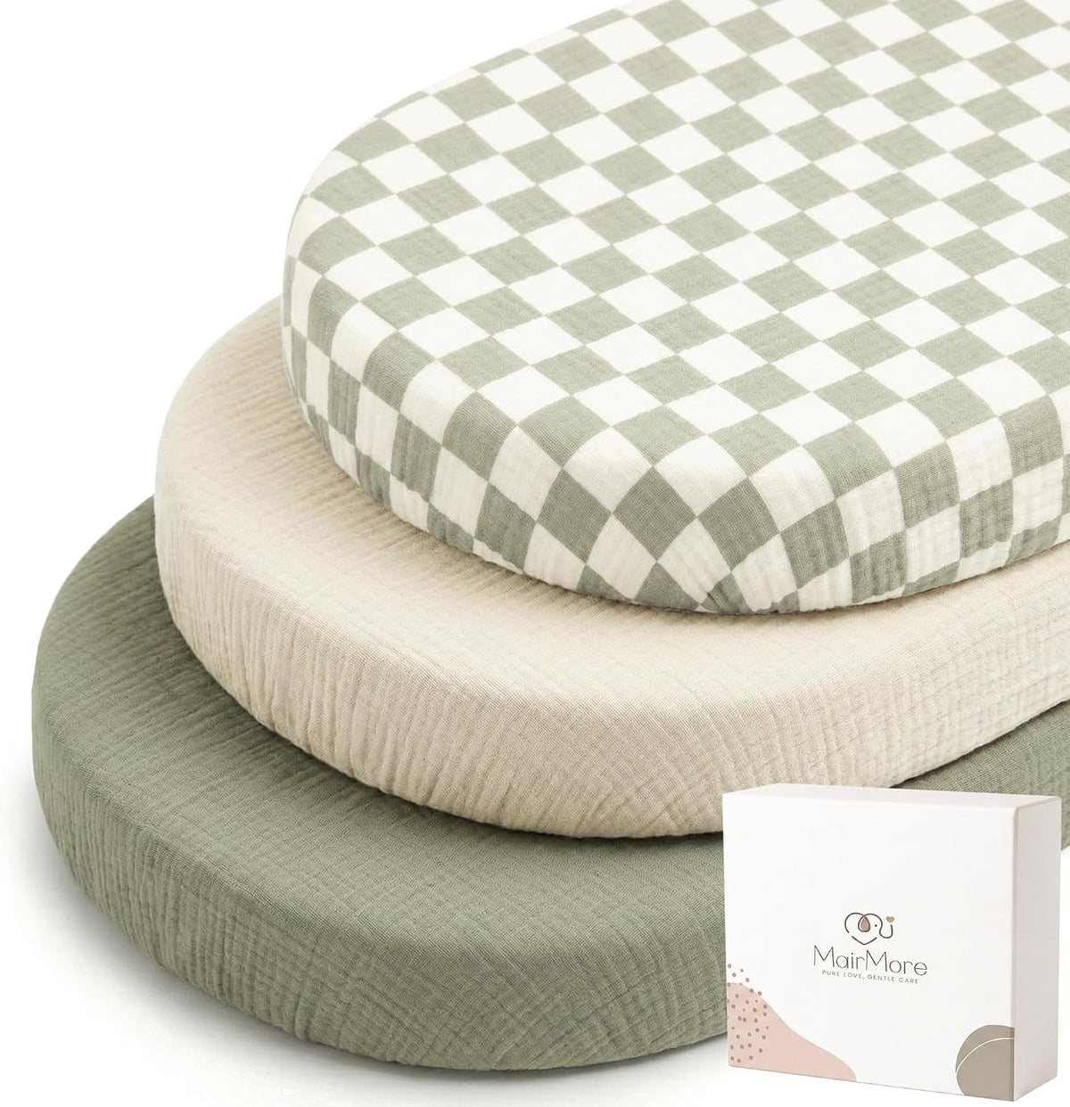 Three stacked oval bassinet fitted sheets in muslin fabric: top sheet has a sage green and white checkerboard pattern, middle is solid light beige, and bottom is solid sage green. A white MairMore product box is shown at lower right.