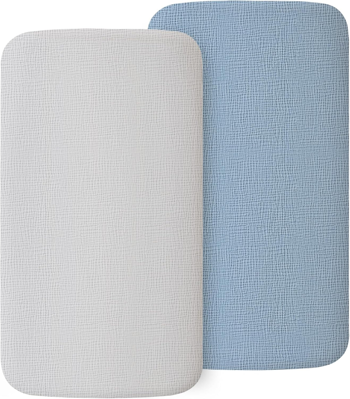 Two rectangular fitted bassinet sheets with rounded corners and a visible muslin weave texture, shown overlapping. One sheet is white, the other is light blue. Both have a soft, breathable woven fabric surface.