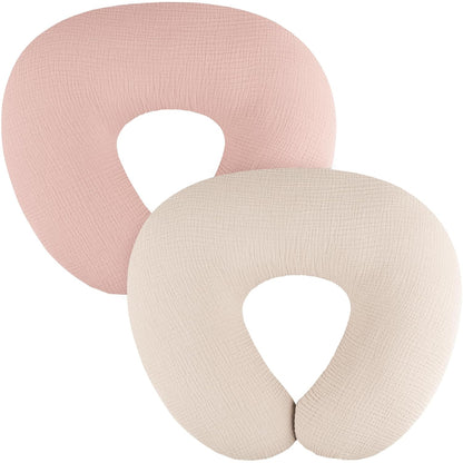 Two U-shaped nursing pillow covers in dusty pink and cream, shown overlapping on a white background. Both feature a subtle woven muslin texture and a U-shaped opening at the bottom.