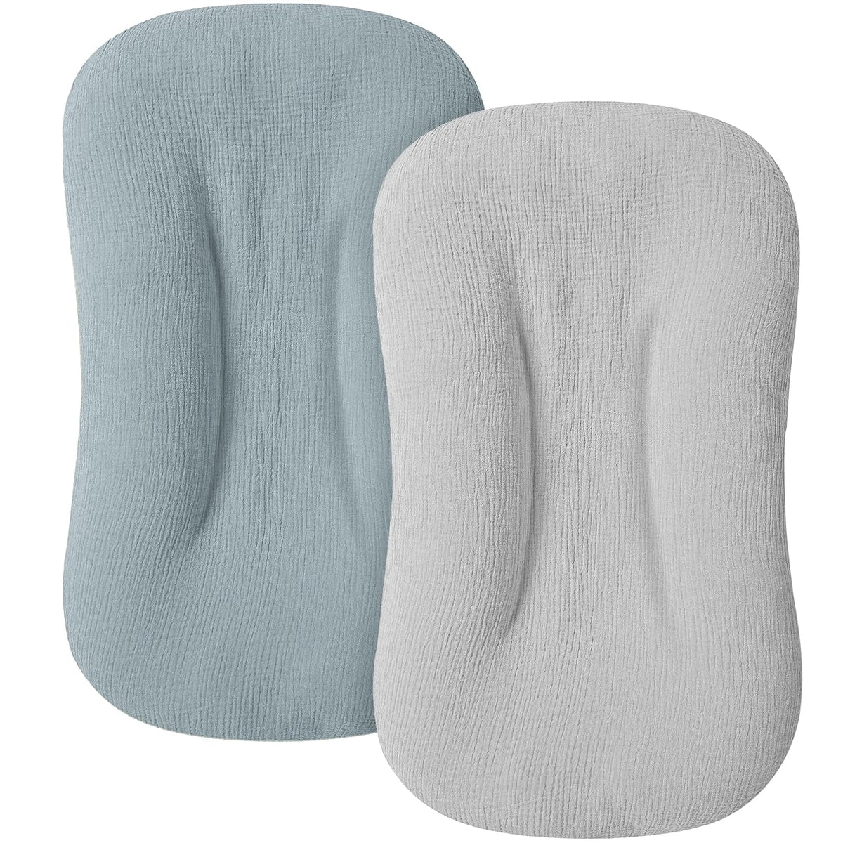 Two oval-shaped baby lounger covers with textured muslin fabric, shown overlapping. Left cover is muted teal blue; right cover is light gray. Both feature a contoured center indent and rounded rectangular shape.