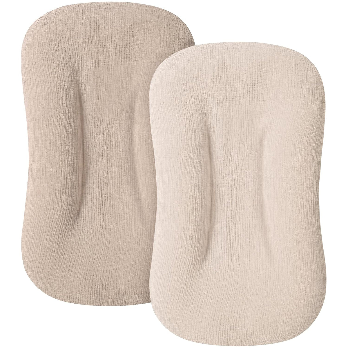Two rounded rectangular baby lounger slipcovers in neutral tones, shown front-facing. Left cover is medium taupe with visible woven muslin texture; right is lighter cream. Both have a contoured, fitted shape.